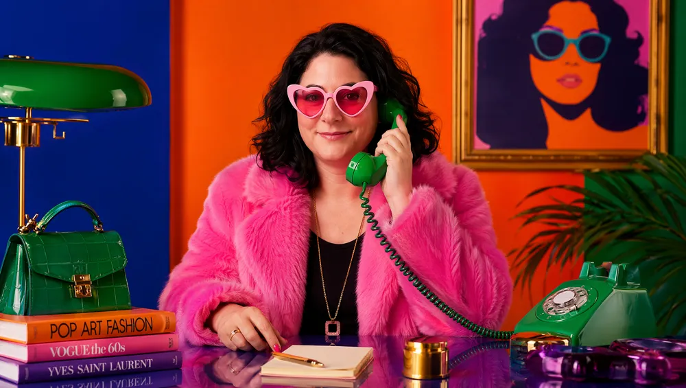 Yaelle David à son bureau pop art, un téléphone vintage vert à la main
